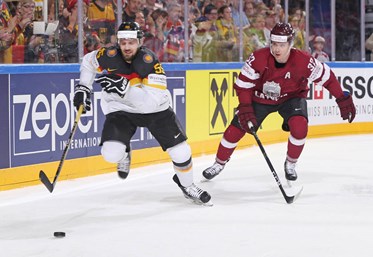 COLOGNE, GERMANY - MAY 16: Germany's Felix Schutz #55 and Latvia's Arturs Kulda #32 chase down a loose puck during preliminary round action at the 2017 IIHF Ice Hockey World Championship. (Photo by Andre Ringuette/HHOF-IIHF Images)

